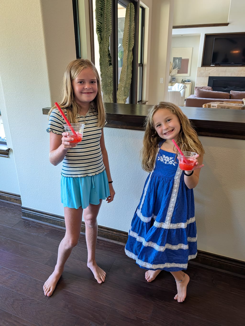 Finley and Harper holding cups of bright red frozen strawberry slush